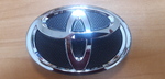 ЭМБЛЕМА ПЕРЕДНЕГО БАМПЕРА TOYOTA COROLLA E150 (06-13) ОРИГИНАЛ